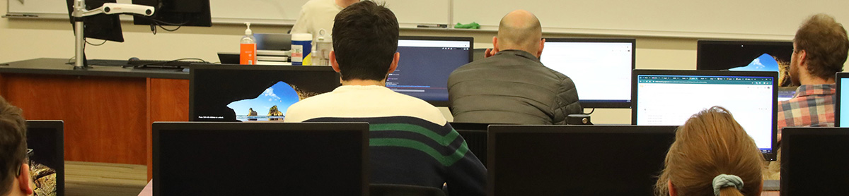 Students using computers with a presenter at the front.