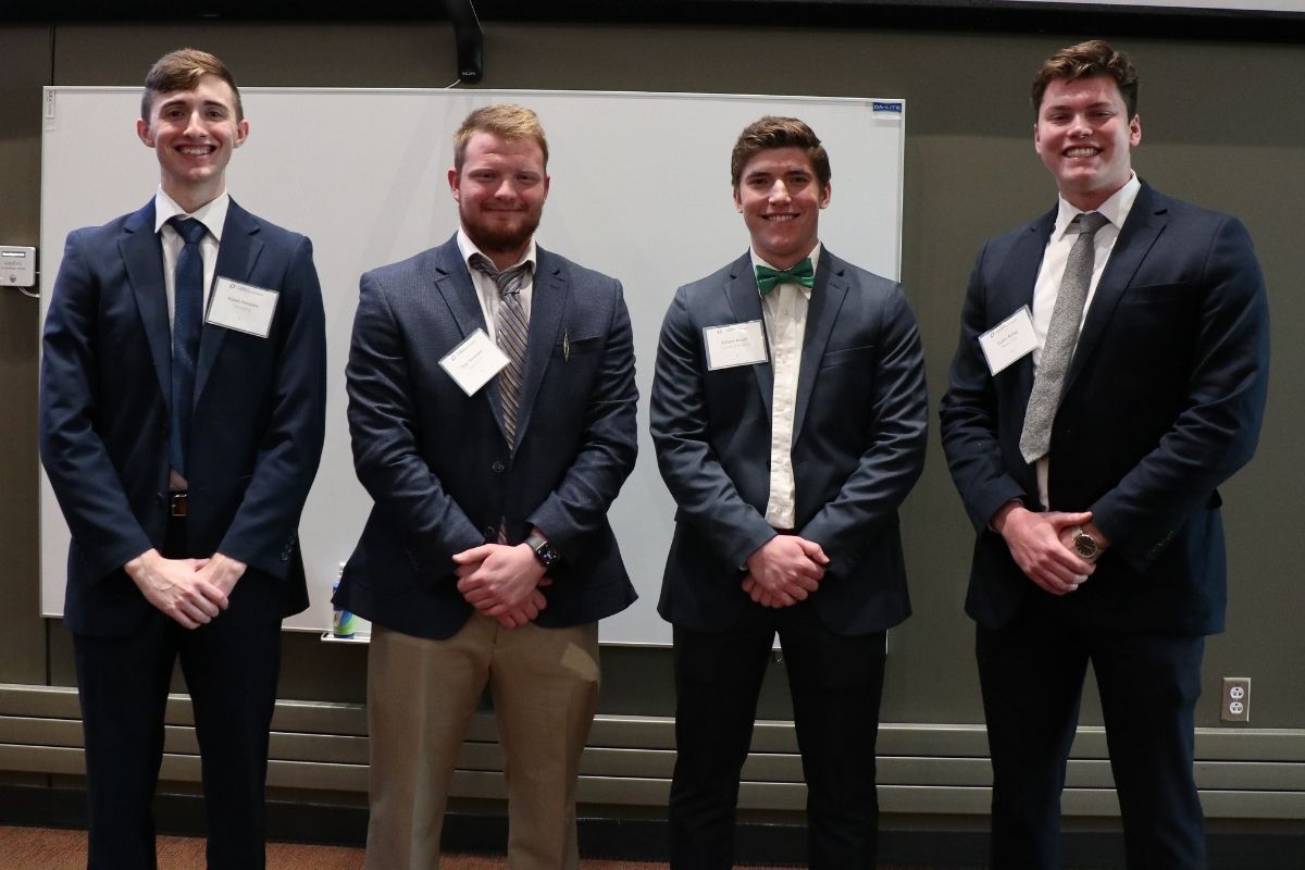 Four male students smiling at the camera