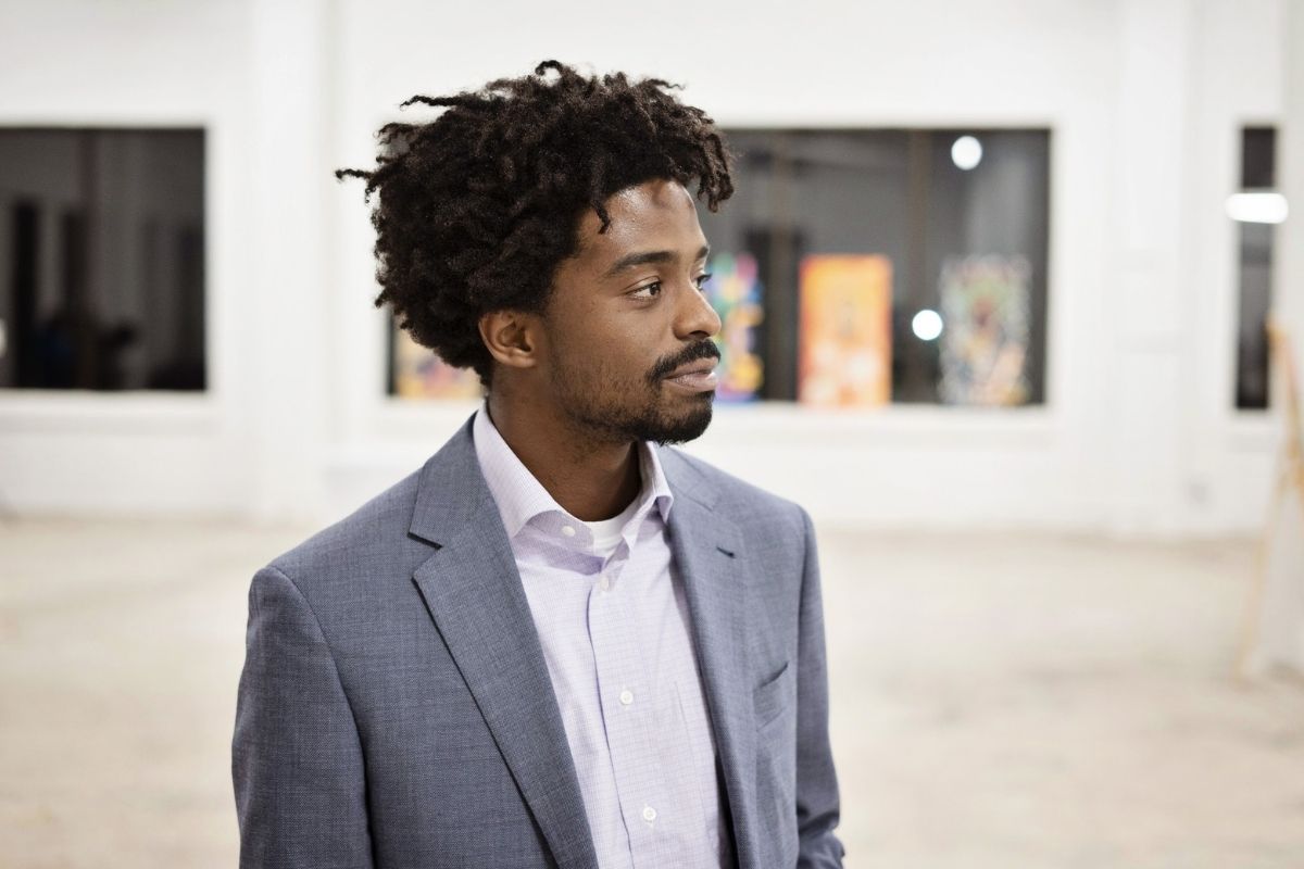 An image of a man in an art gallery looking to the side