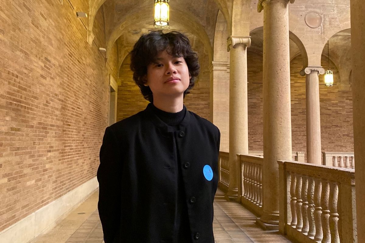 An image of a woman smiling at the camera in a grand building