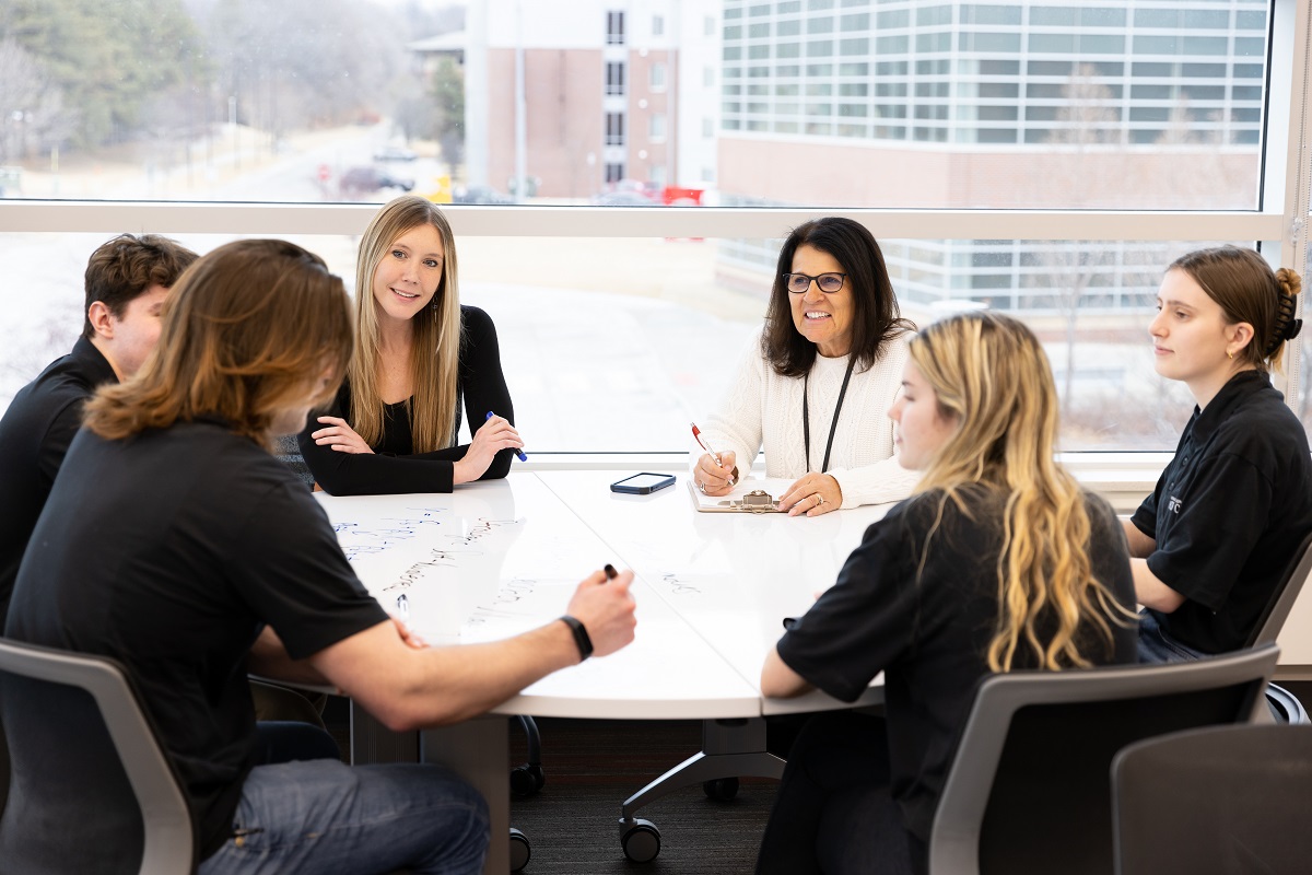 UNO Students and staff sit at table 