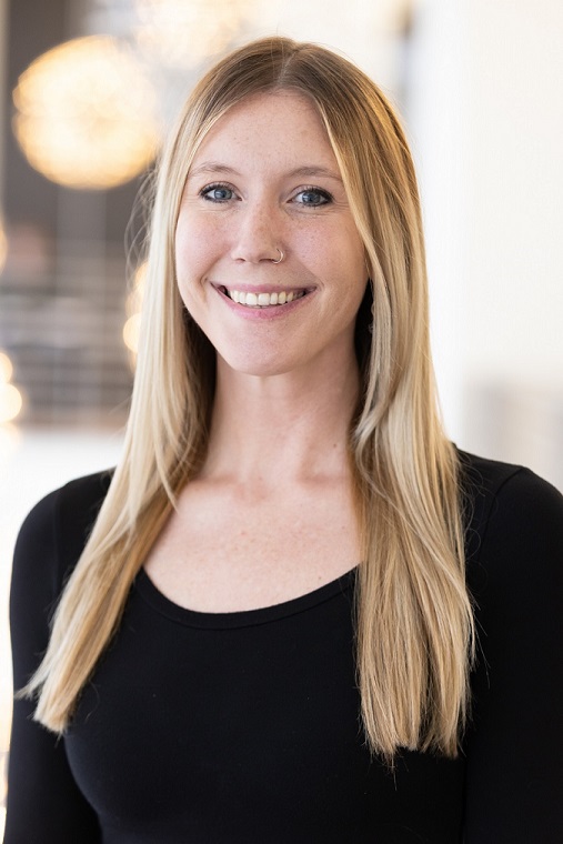 An image of a woman smiling at the camera in a black shirt