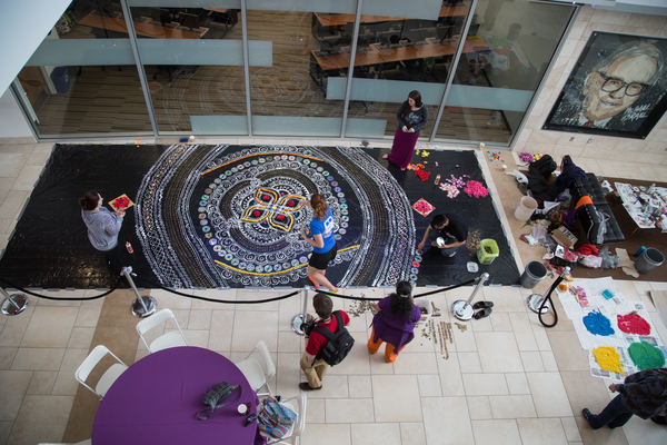 Students working with the artist to make Rangoli