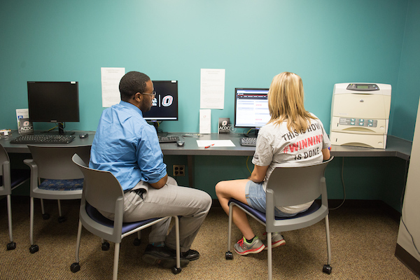 student with advisor at computer station