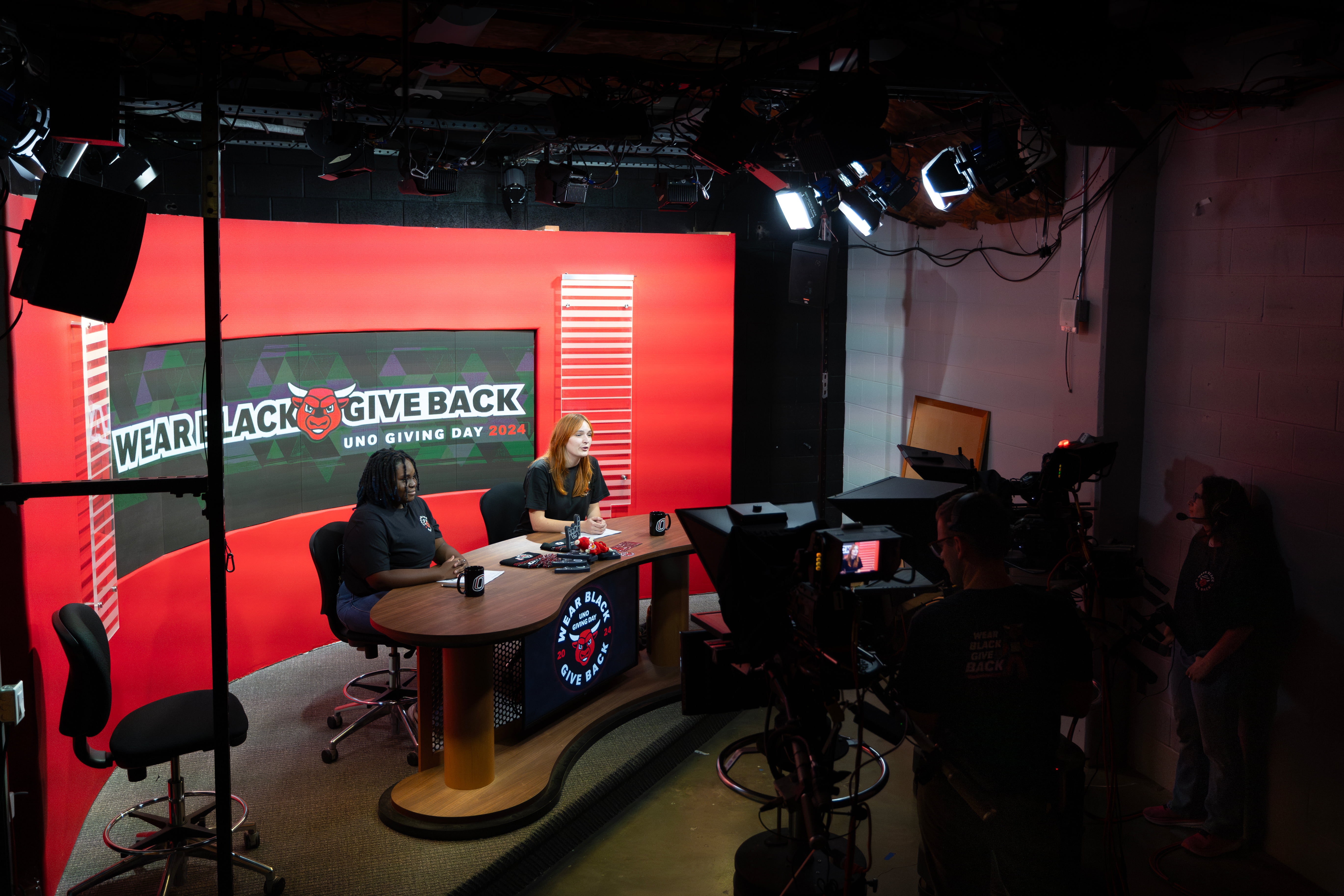 UNO Television studio anchors sitting at a desk.