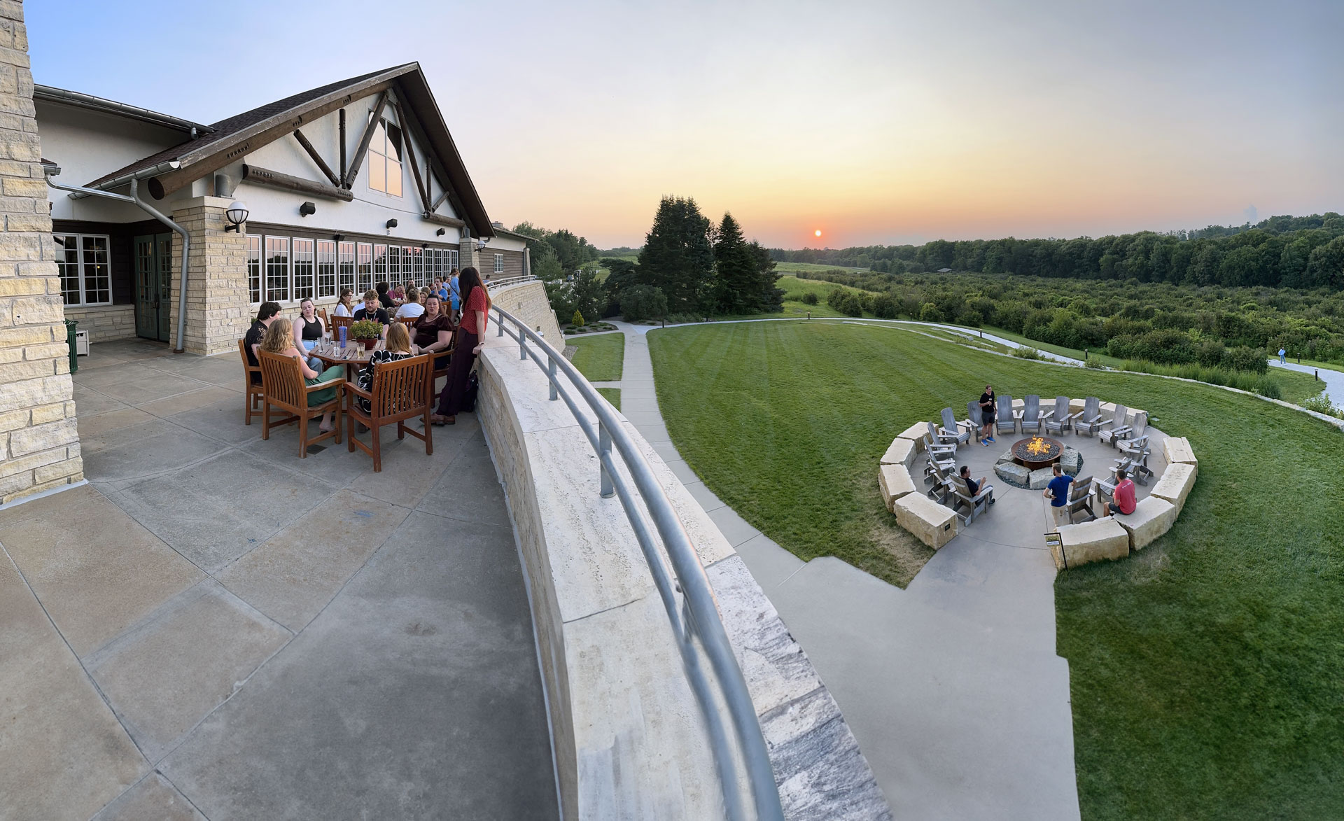 Students and faculty enjoying the sunset on the balcony and the fire pit at the Lied Lodge.