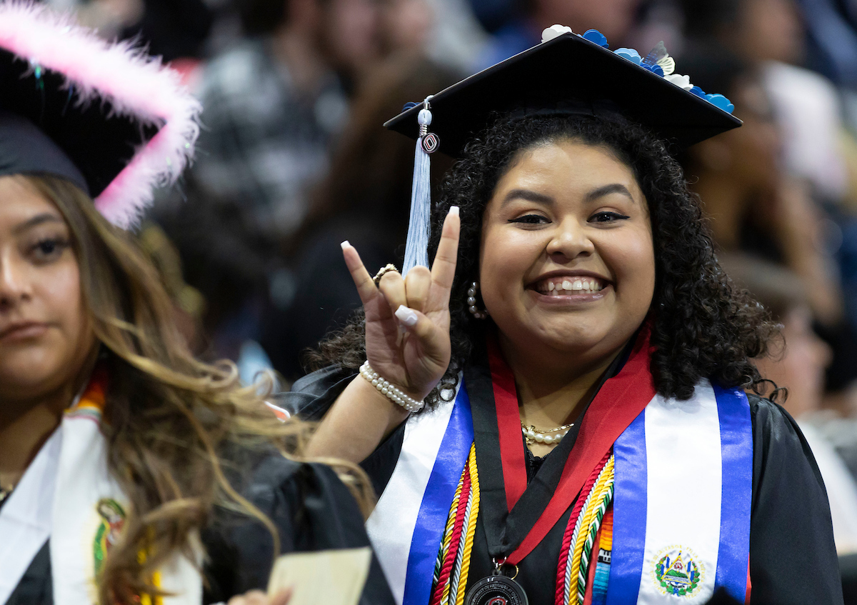 CEHHS alumna, Amy Lopez Hernandez, mingles with new graduates at Baxter Arena during UNO's Commencement