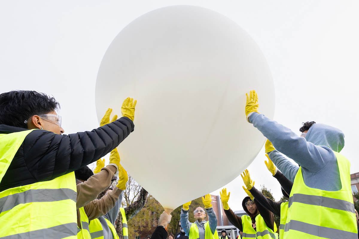 Students work together to hold a near-space balloon in place prior to launch