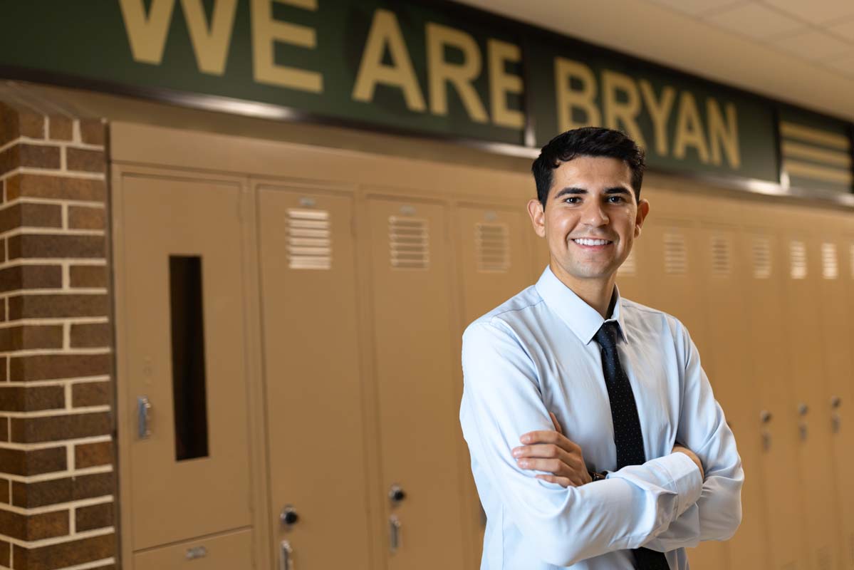 CEHHS alumnus and teacher, Dario Gudino-Garcia, stands in front of a wall of lockers at Omaha Bryan High School