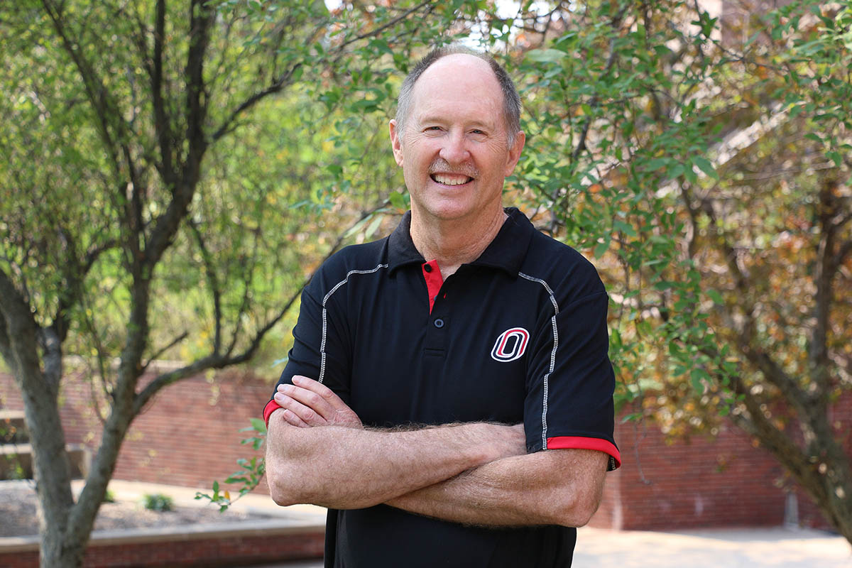 Dr. Neal Grandgenett stands in outside Roskens Hall at UNO