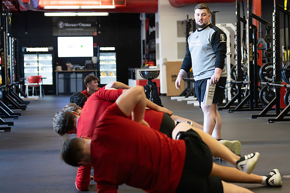 A student worker instructs athletes in injury prevention work
