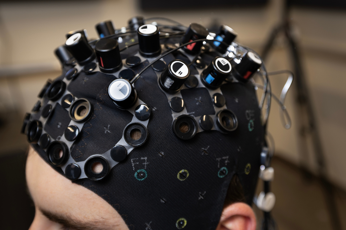 a person is wearing a specialized piece of equipment on their head to study brain activity.