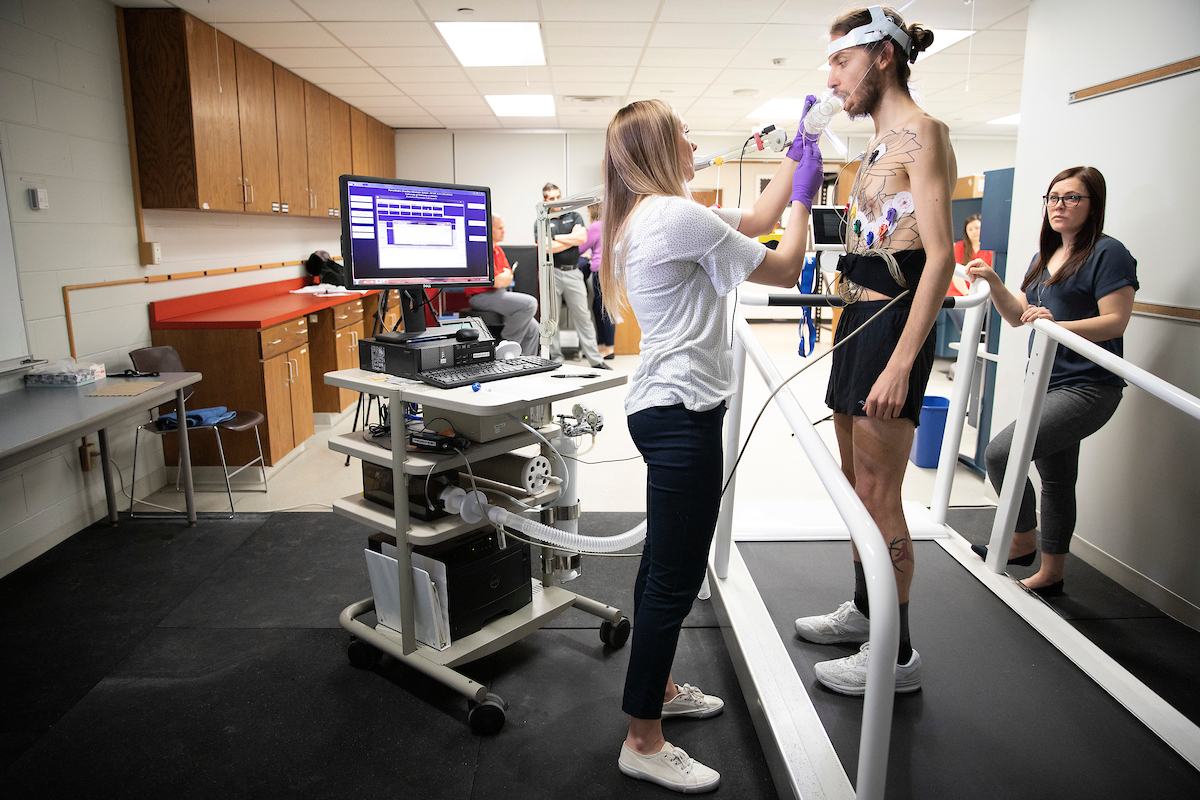 subject having metabolic cart equipment checked while on treadmill