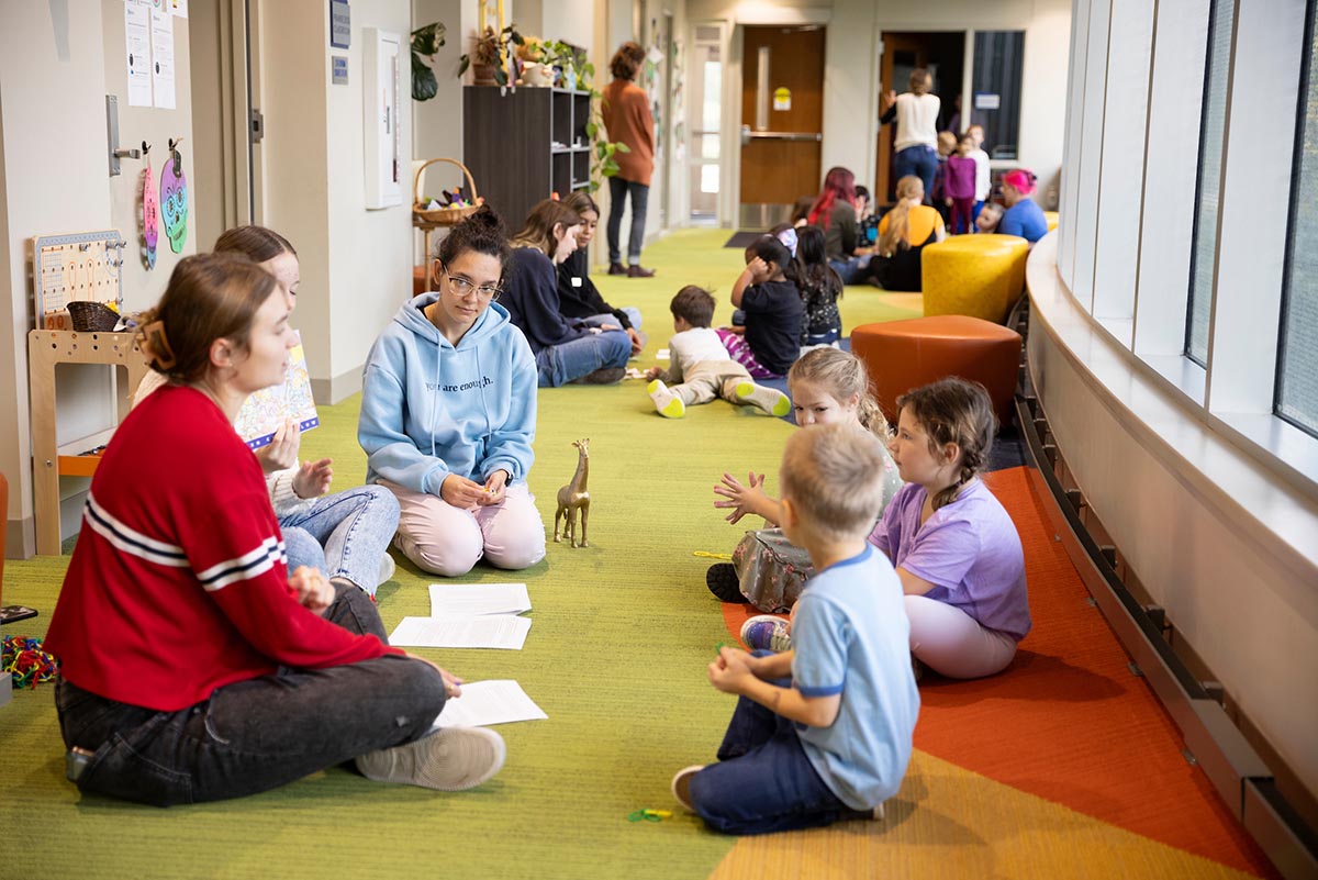 Several education students work with kids in a school