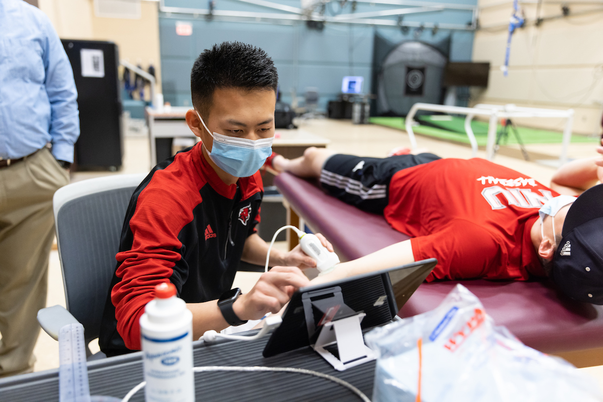 A student works with a pitcher in the Pitching Lab