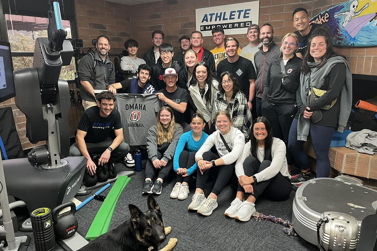 A group of people pose together in a sports medicine facility.