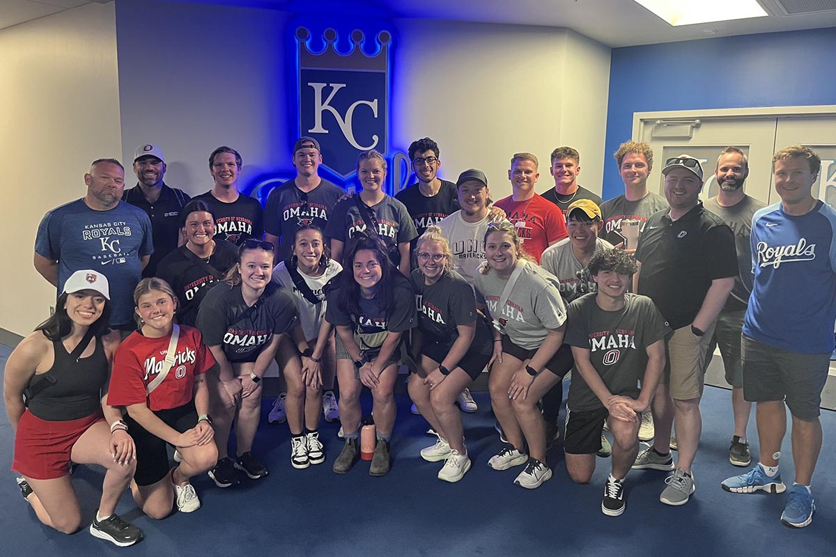 A group of people pose together in a sports complex.