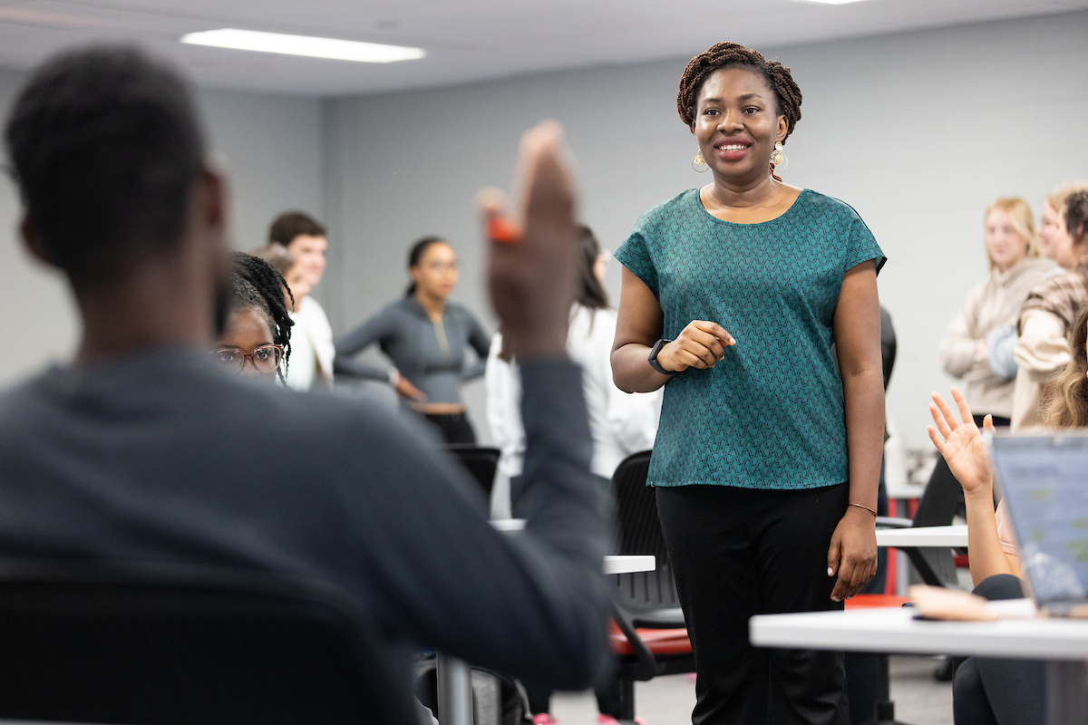 Dr. Ayo Olagoke stands in a classroom with her public health students