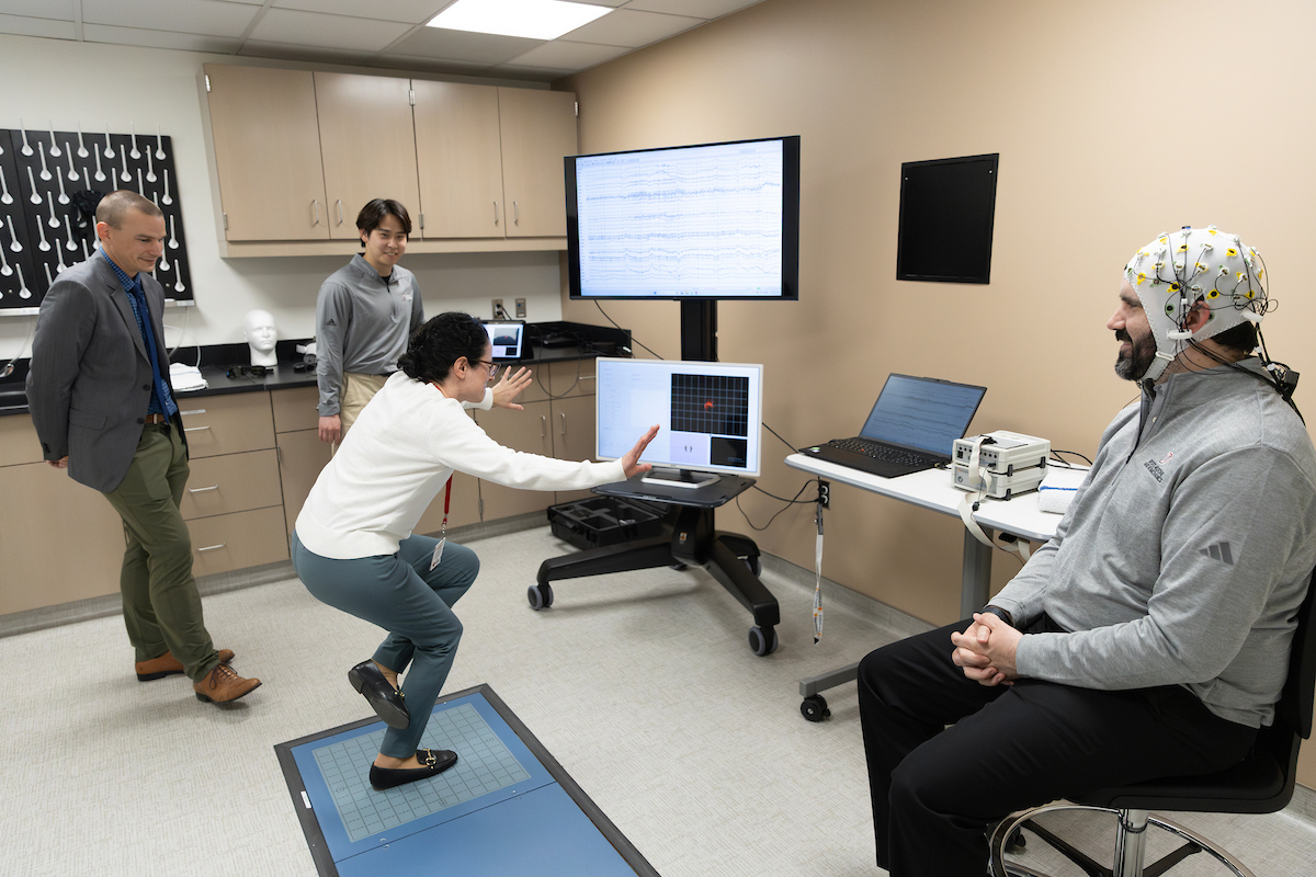 A group of people demonstrate a new lab space in the Health Science Collaborative 