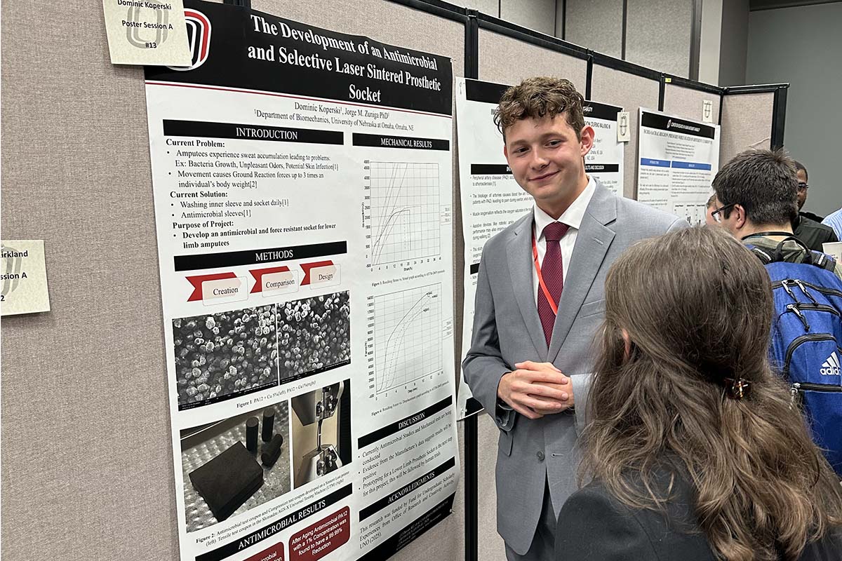 A student presents a poster at a conference