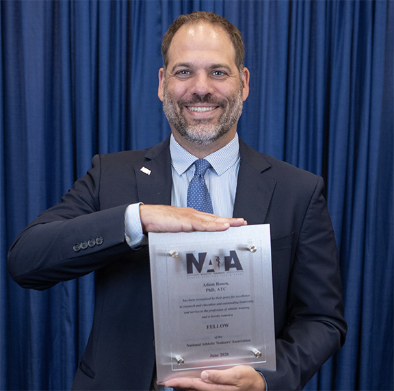 Dr. Adam Rosen holds an award
