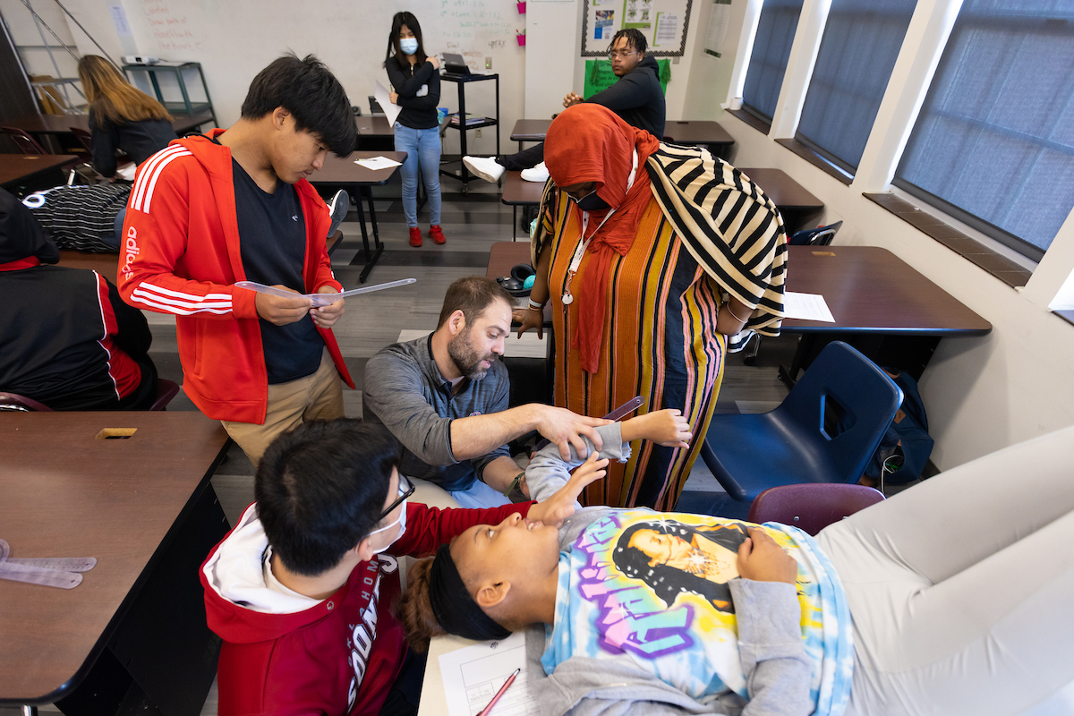 Dr. Adam Rosen works with high schoolers at Omaha Benson High