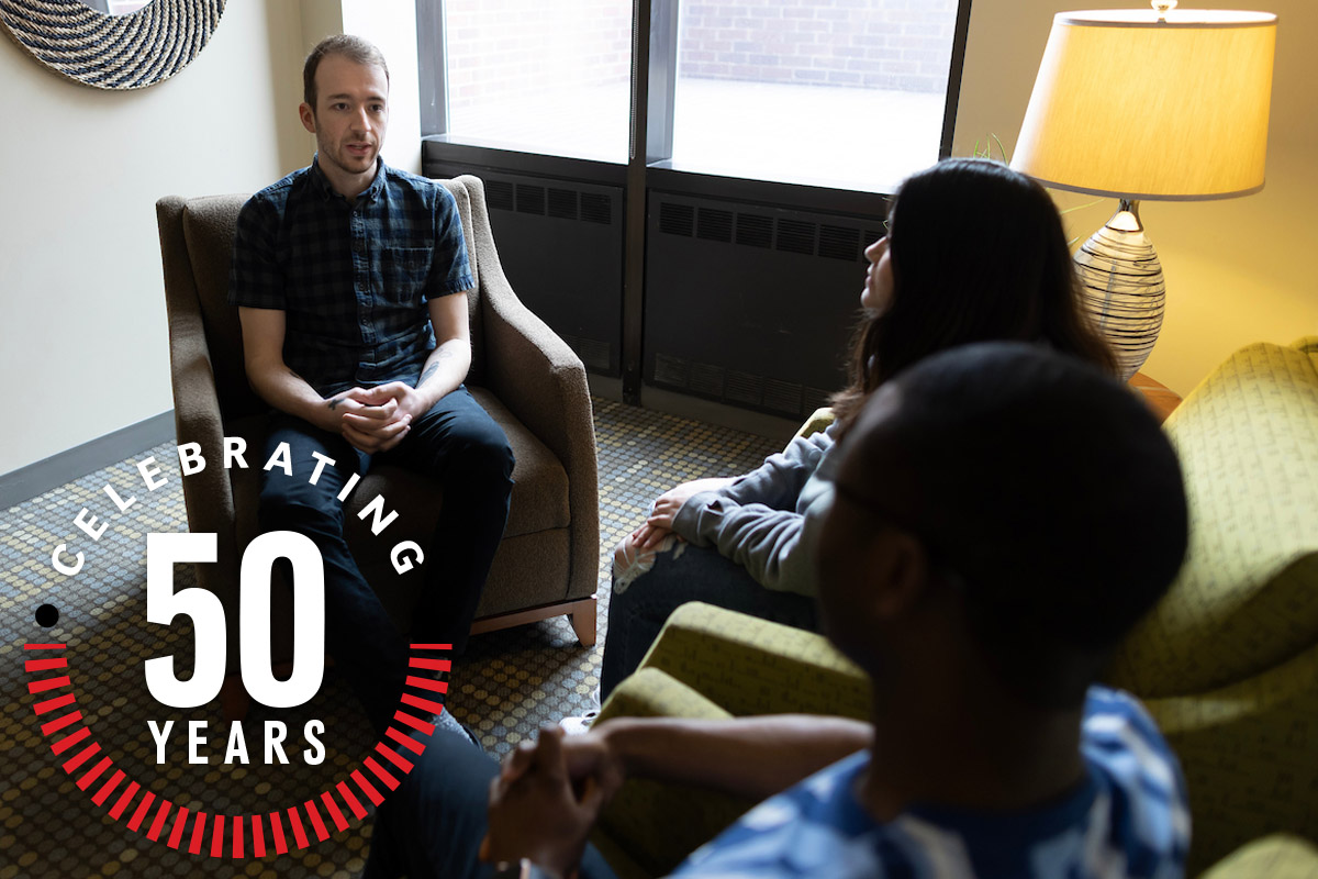 A student clinician works with a couple in the UNO Community Counseling Clinic with text: Celebrating 50 years