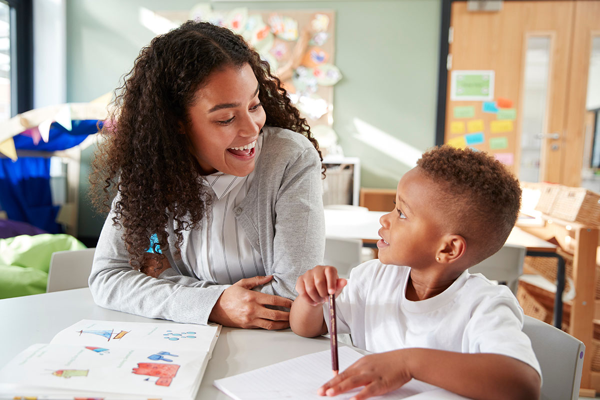 A teacher works with a child in a classroom