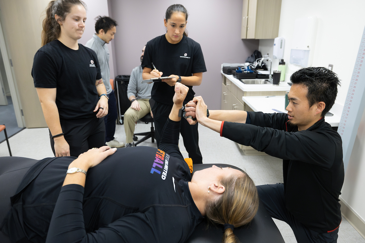Sports medicine and biomechanics students working with a softball athlete