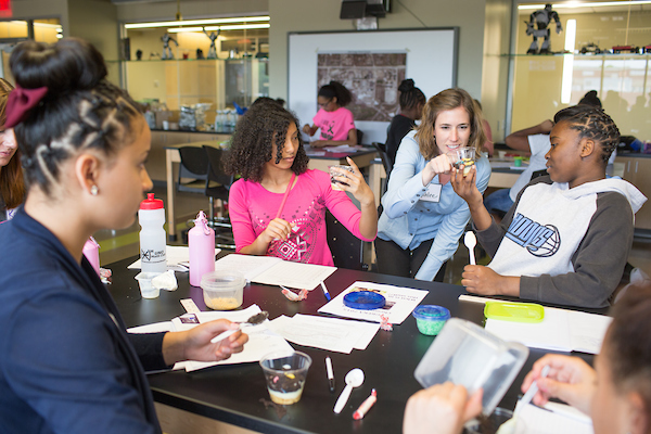 A teacher helps teenage students in the classroom