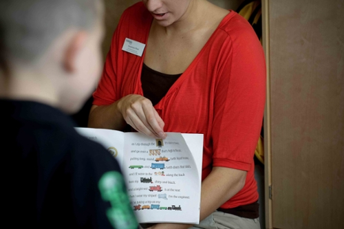 Teacher reading a book to a child