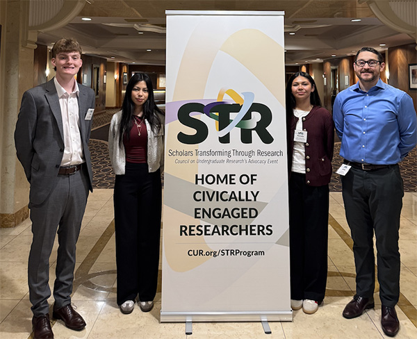 A group of people pose for a photo at a conference