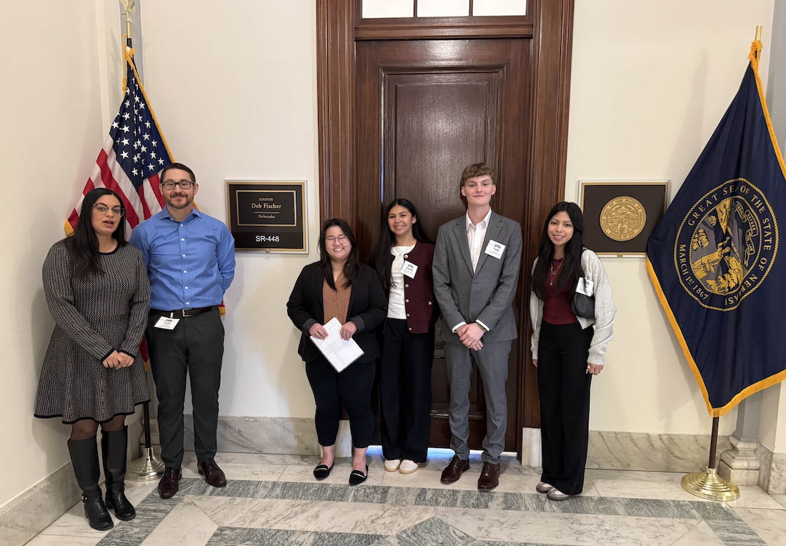 A group of people pose for a photo in the office of a state senator