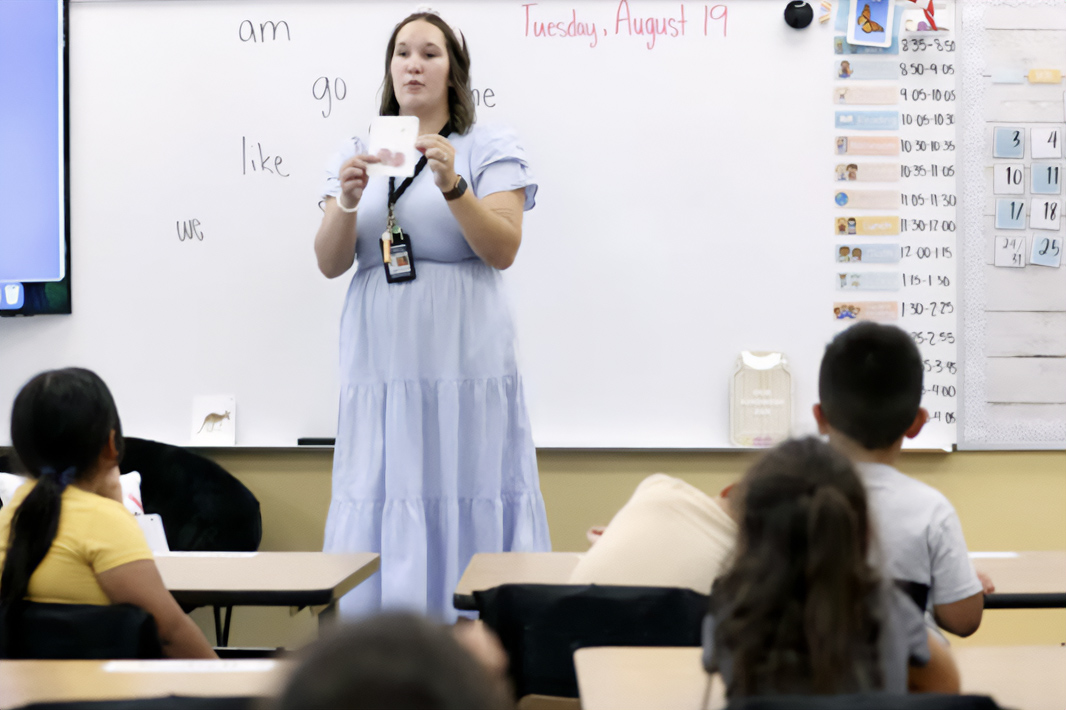 A teacher stands at the front of a classroom