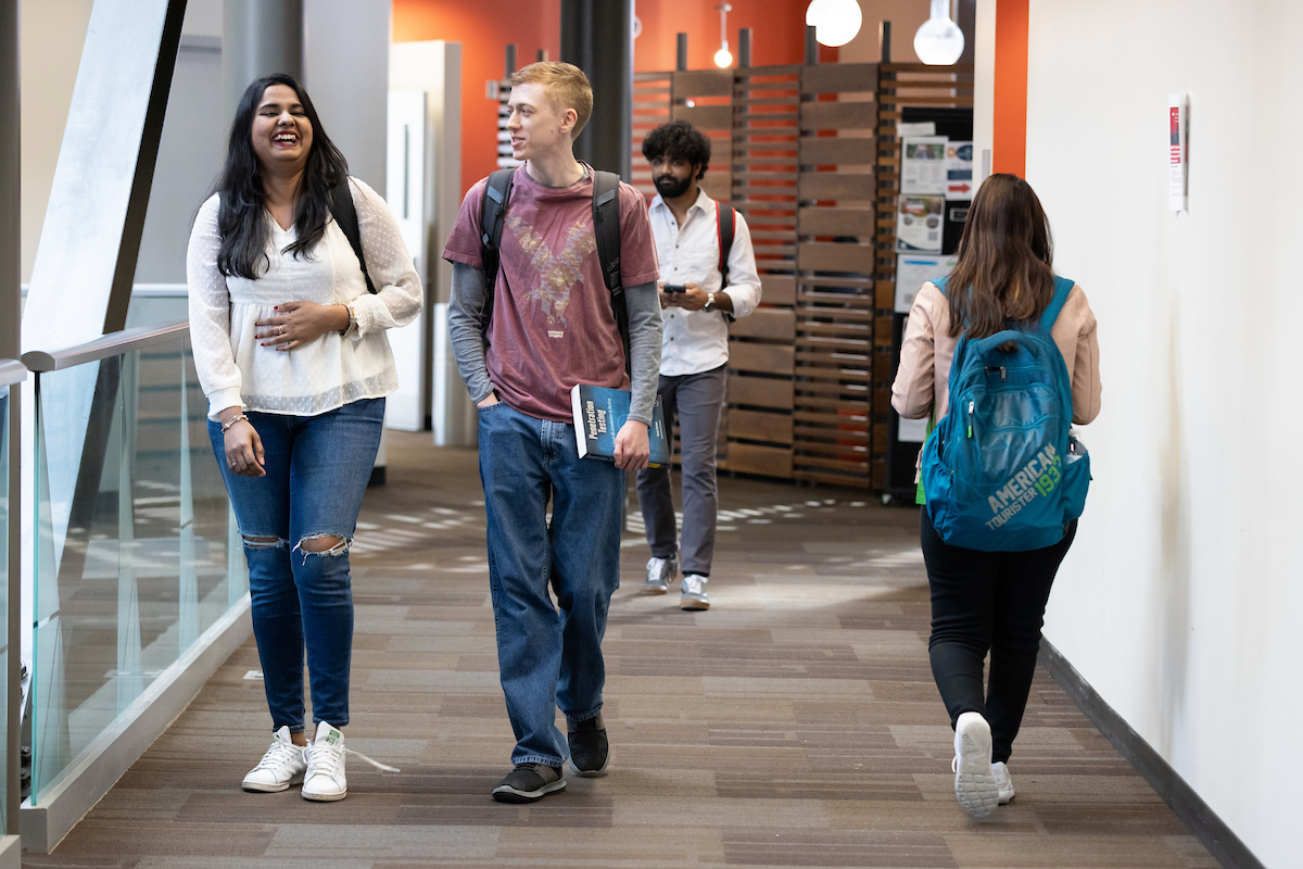 Two students walk and talk on UNO campus.