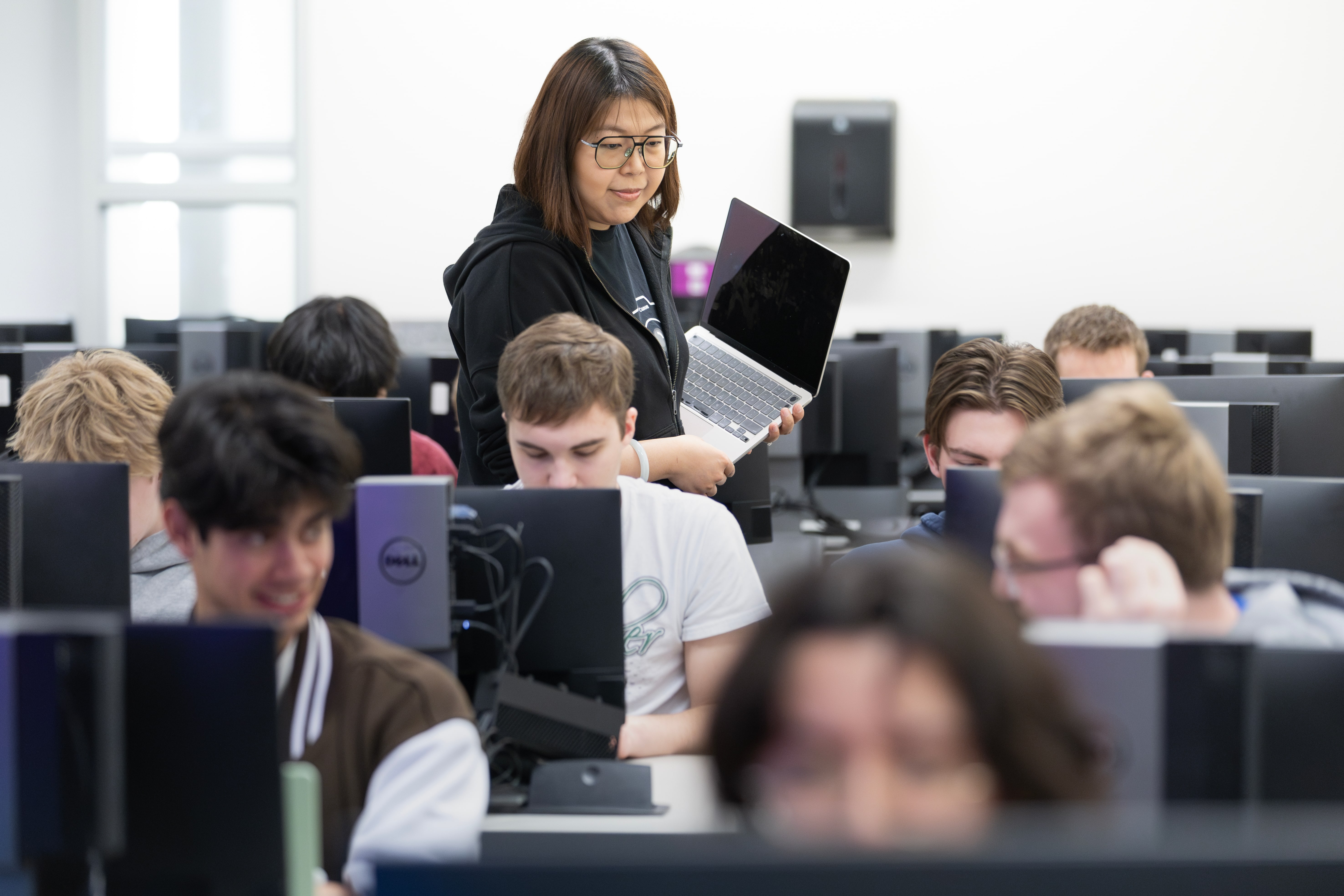 Students competing in computer science quiz bowl at desktop computers