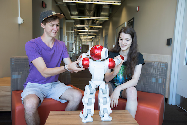 Two students work with a robot