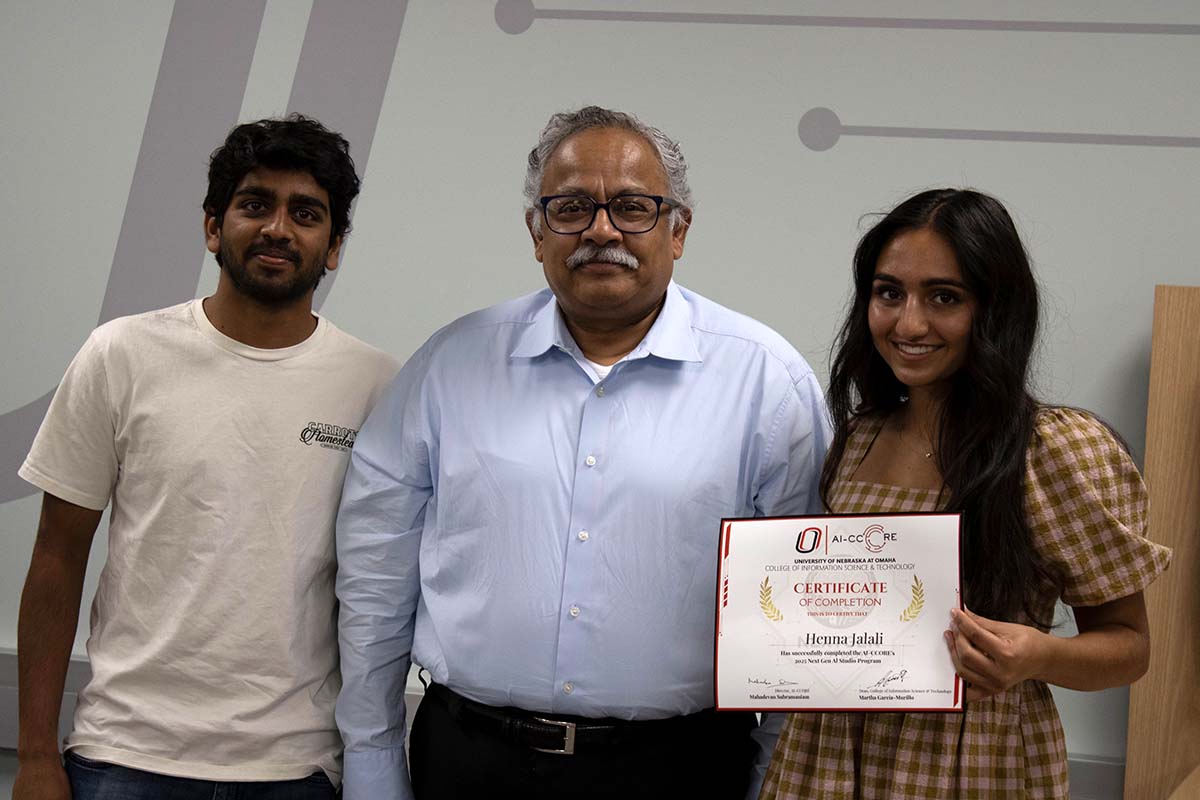 Mahadevan Subramaniam, Ph.D. stands between two students holding an AI-CCORE NextGen AI Studio Certificate of Completion in a university classroom.
