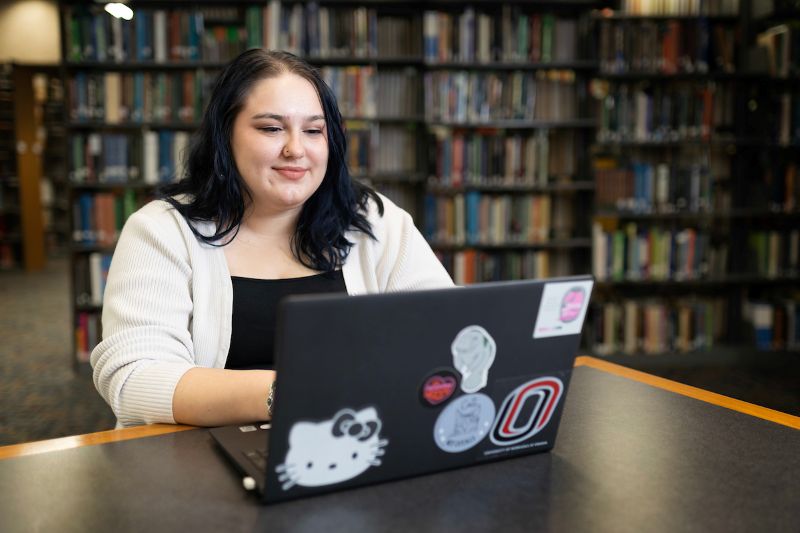 student working on a laptop in the library