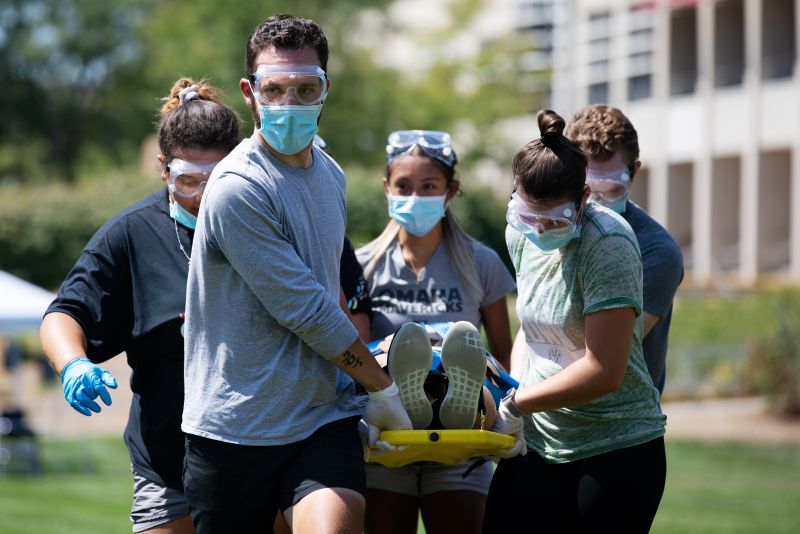group of students in emergency gear holding stretcher