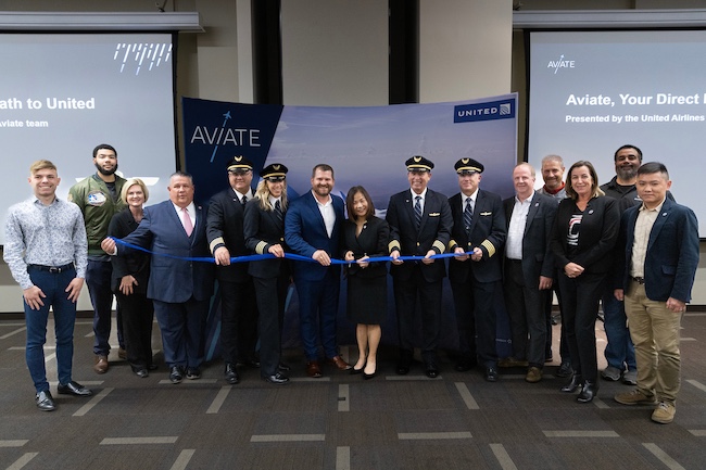 Faculty and Staff with United Airlines Representatives cutting a ribbon