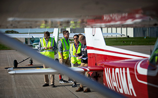Students wearing visibility vests on a tarmac