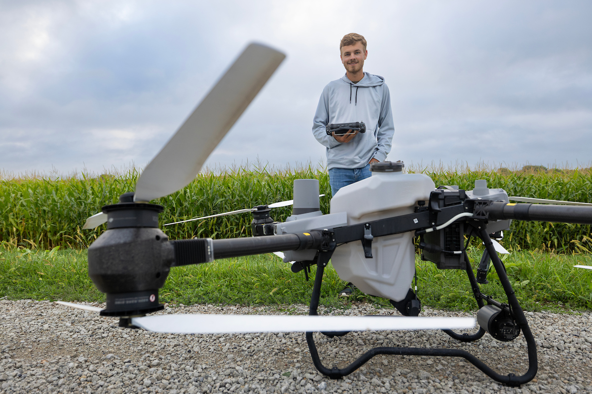 Large drone with pilot standing behind it. 