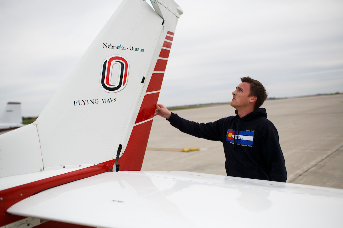 Student touching the elevator of an airplane.