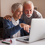 photo of older adults pointing at a laptop