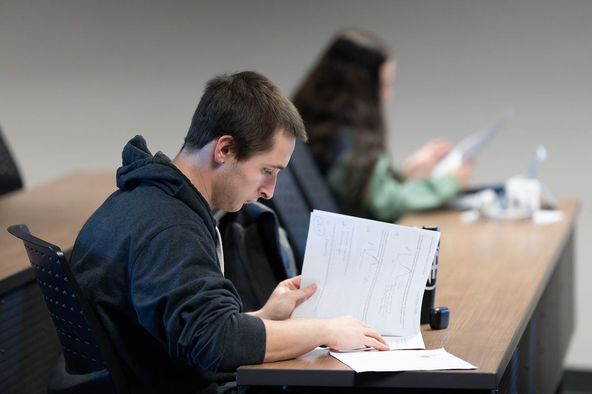 Student taking a paper exam in a classroom.