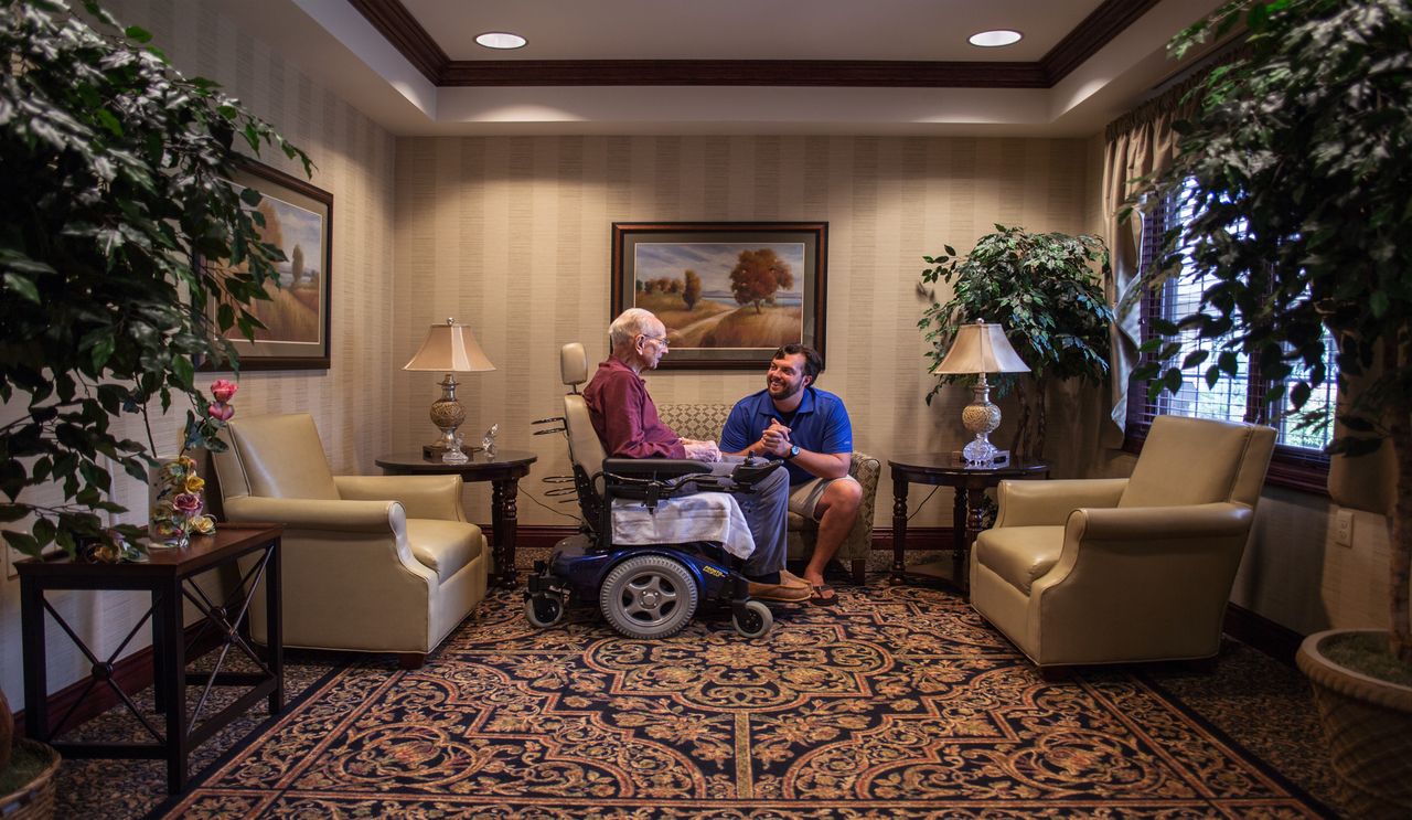 Male student sitting with older man in wheelchair