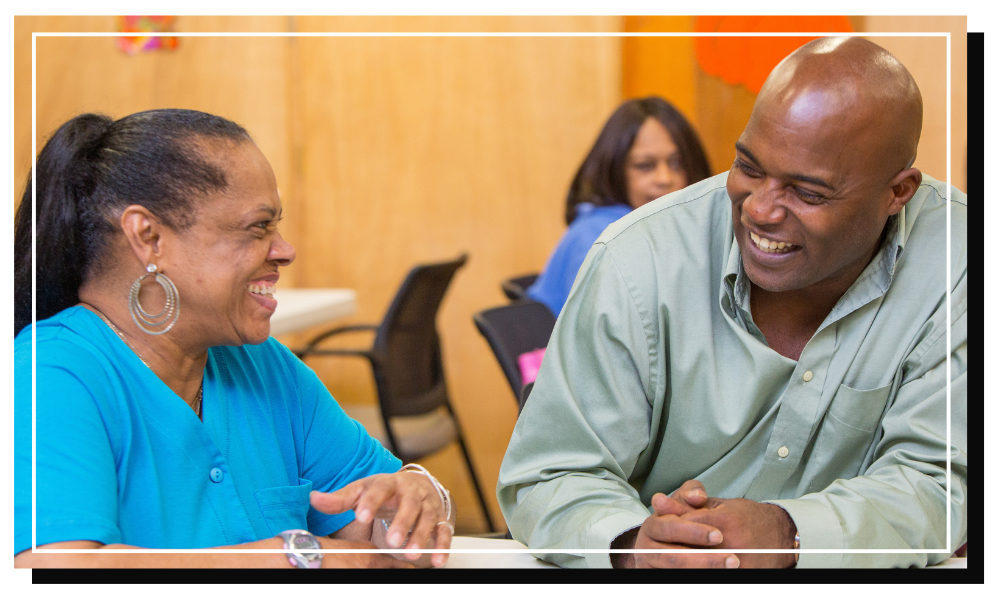 adult student sitting with elderly adult.