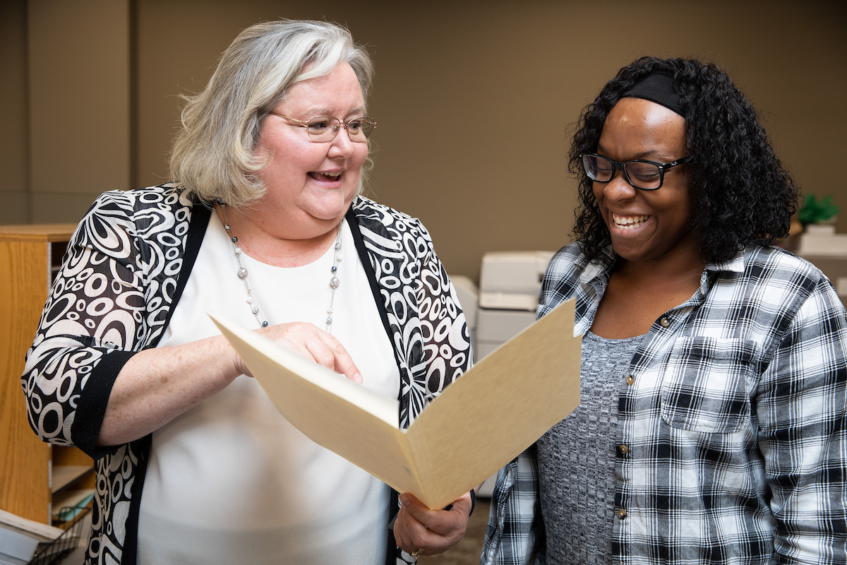 student looking over a folder with an instructor