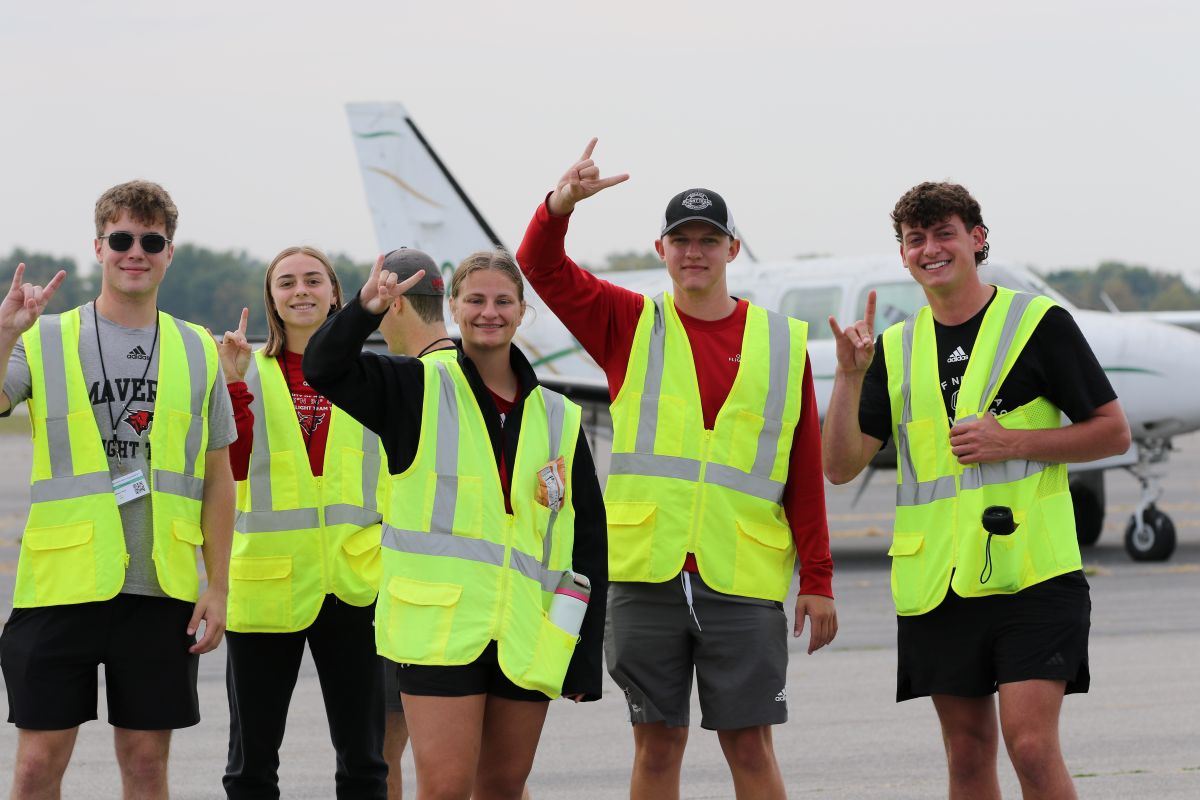 UNO students flight team standing in front of an airplane.